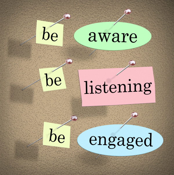 Be Aware, Listening and Engaged words on papers pinned to a bulletin or message board to illustrate the need to pay attention when managing an organization